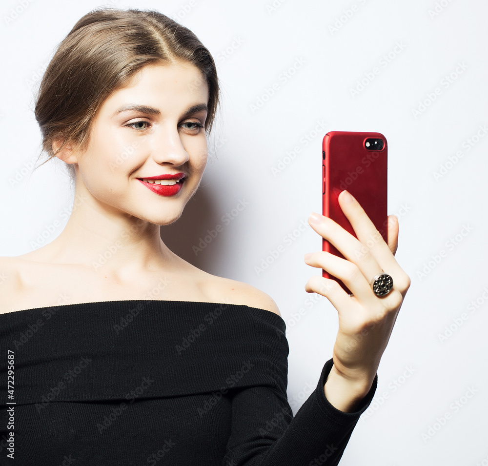 Selfie time. Young smiling blond woman doing selfie on white background. Selfie time. Young smiling blond woman doing selfie on white background.
