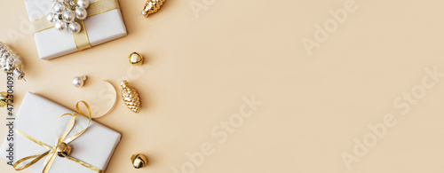 Banner made of Christmas presents and gifts and gold and silver decorations on beige background. Merry christmas, New Year holiday concept. Flat lay, top view, copy space.