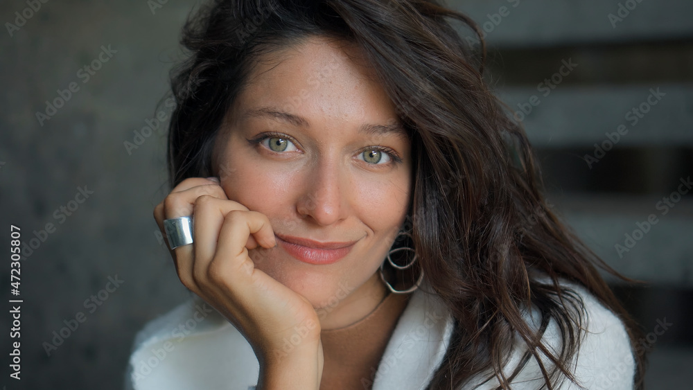 beautiful European girl long-haired brunette sits at home on the stairs in autumn clothes and a white sweater and smiling touches herself with her hands beautiful European girl long-haired brunette sits at home on the stairs in autumn clothes and a white sweater and smiling touches herself with her hands