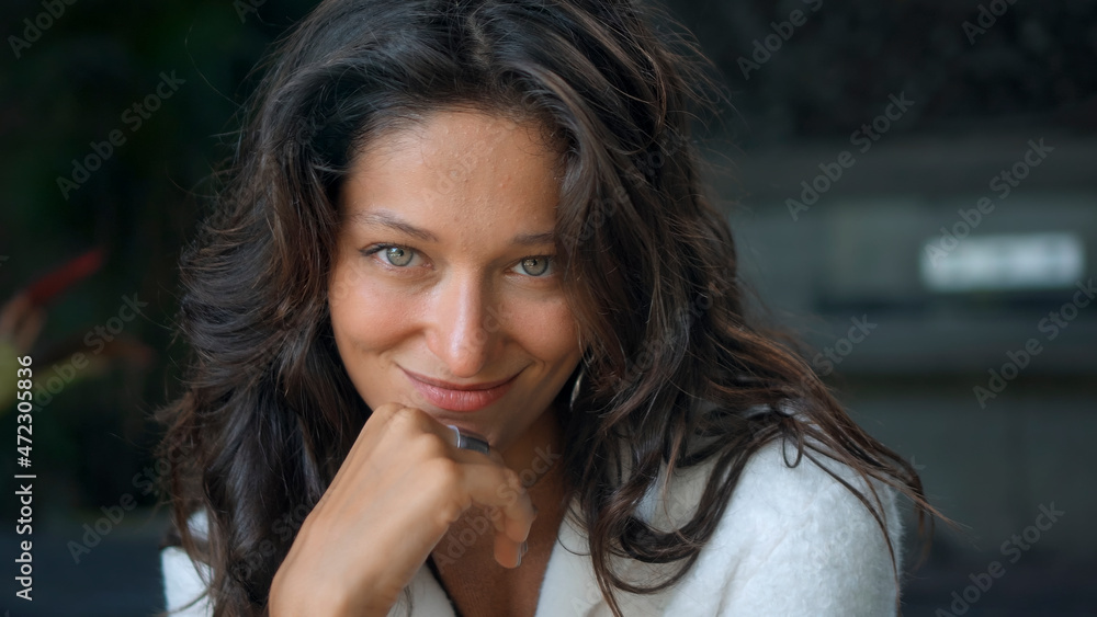 Obraz premium beautiful European girl long-haired brunette sits at home on a bench in autumn clothes and a white sweater and smiling looks forward
