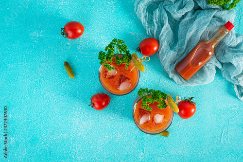 Alcohol cocktail Bloody Mary on blue background. Classic cocktail with tomato juice and vodka. Top view photo