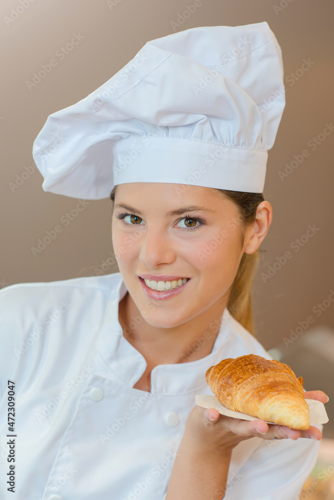 Bakery worker holding a croissant Bakery worker holding a croissant