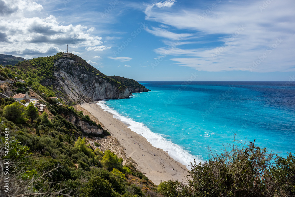 Mylos scenic sandy beach with azure vibrant waves on green coast of Lefkada island in Greece. Summer nature vacation travel to Ionian Sea