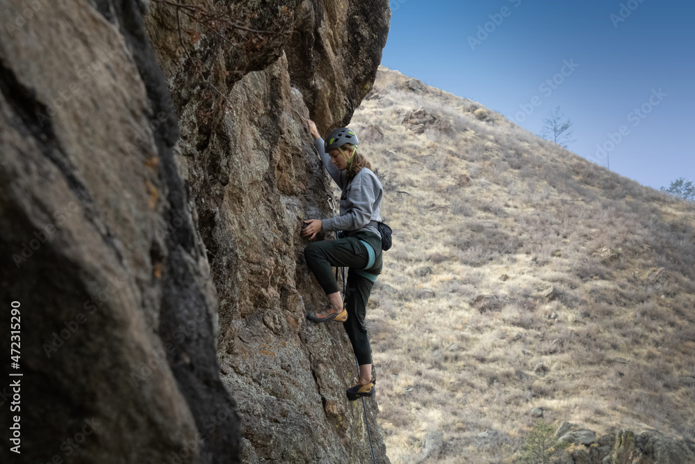 Female rock climber in Colorado takes on a challenging climb.