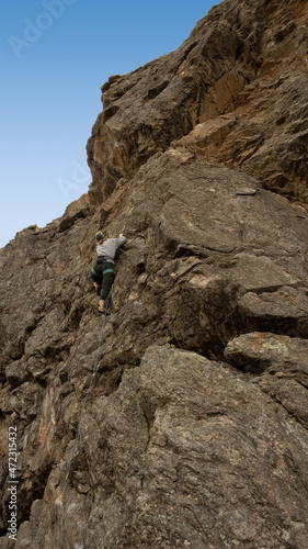 Women climbs a big cliff in Colorado