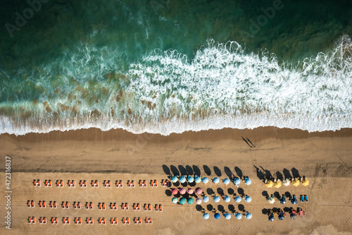 Sombrillas ordenadas en la playa. Arena y mar en vista cenital  photo