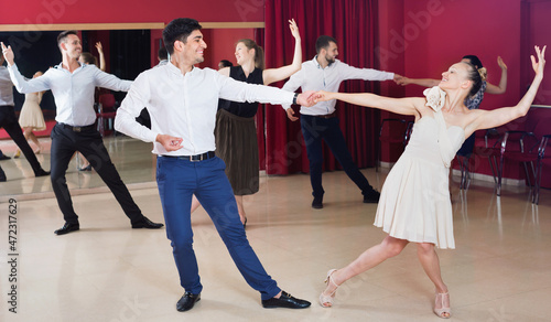 Happy cheerful pleasant people learning to dance waltz in dancing class