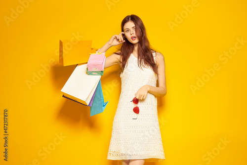 smiling woman with packages in hands Shopaholic yellow background