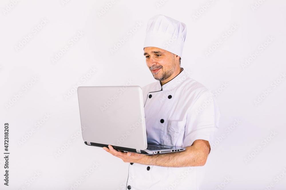 Chef cook wearing kitchen jacket and hat, holding a laptop and showing its screen, on white background Chef cook wearing kitchen jacket and hat, holding a laptop and showing its screen, on white background