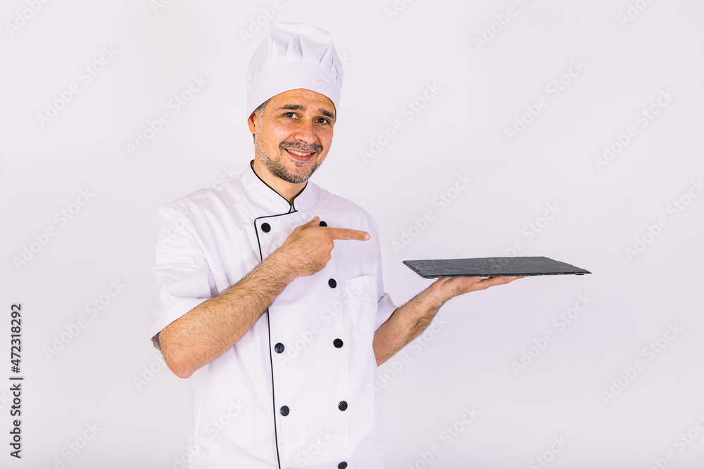 Chef cook wearing cooking jacket and hat, holding a slate plate, on white background Chef cook wearing cooking jacket and hat, holding a slate plate, on white background