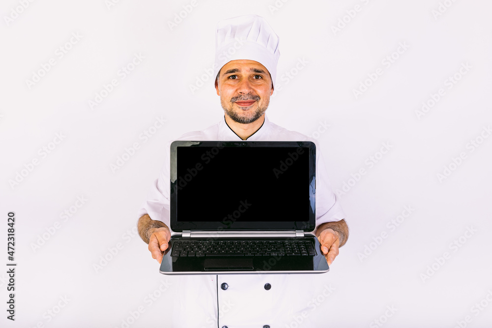 Chef cook wearing kitchen jacket and hat, holding a laptop and showing its screen, on white background Chef cook wearing kitchen jacket and hat, holding a laptop and showing its screen, on white background