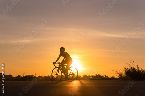 Silhouette of cyclist in motion on the background of beautiful sunset