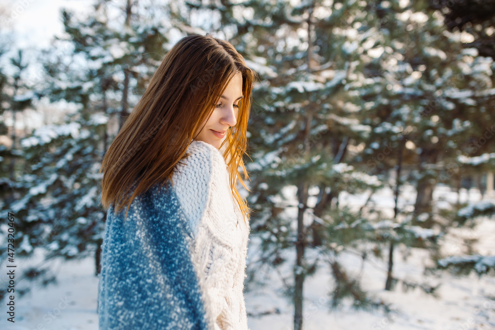 Portrait of a red-haired girl in mittens against the background of a winter park. Beautiful woman is enjoying nature on a snowy day. Portrait of a red-haired girl in mittens against the background of a winter park. Beautiful woman is enjoying nature on a snowy day.