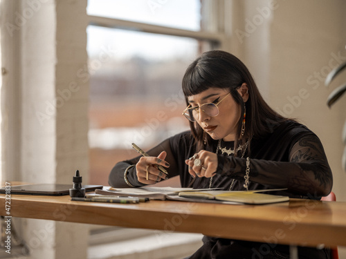 Non binary Indigenous artist drawing indoors photo