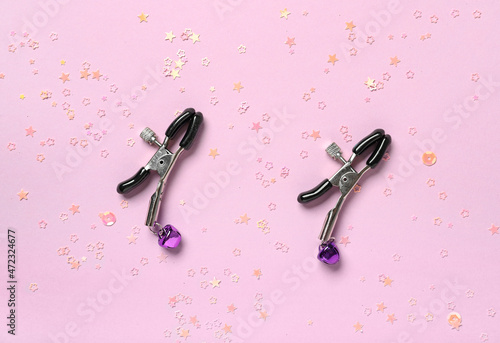 Nipple clamps on color background photo