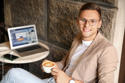 Handsome young man with cup...