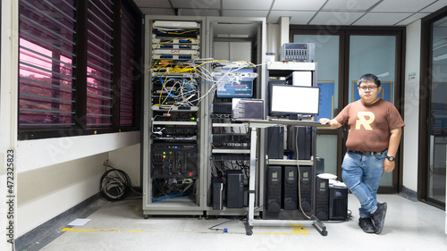 Slika na platnu The system administrator works in the server room of the data center