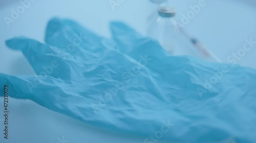 Wallpaper Mural Blue medical gloves, syringe, medicine bottle rotating on the surface, selective focus, close-up Torontodigital.ca