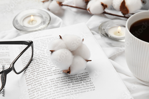 Opened book, eyeglasses, cu...