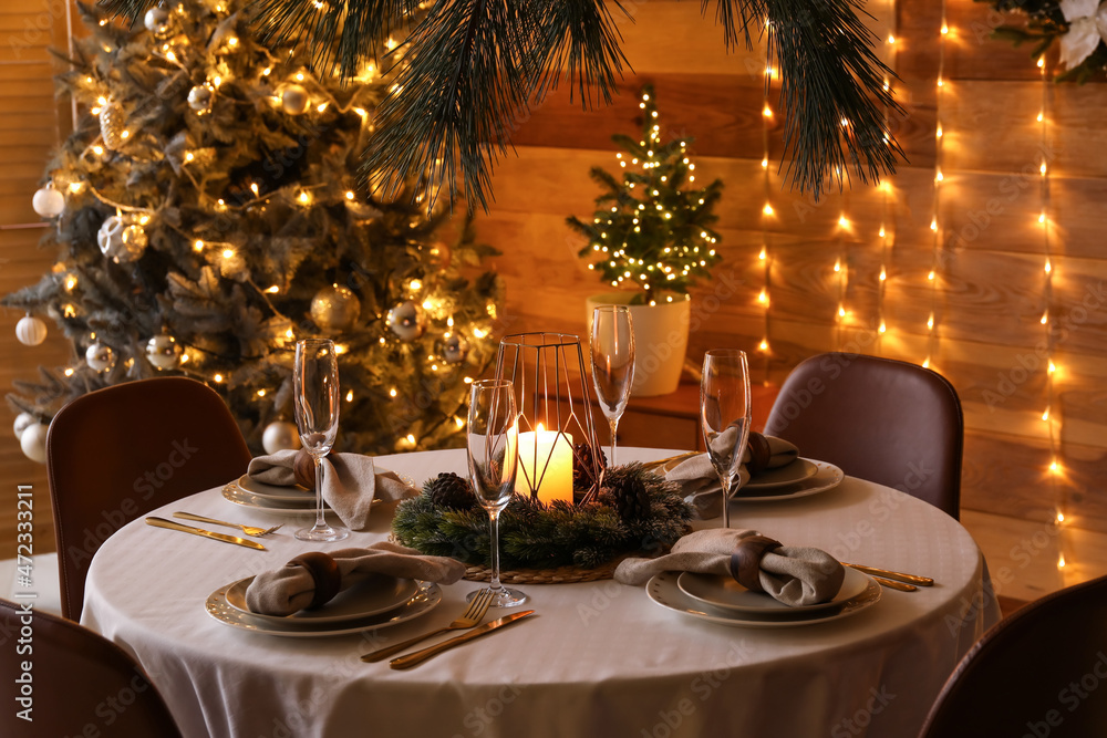 Fototapeta premium Dining table with beautiful setting for Christmas celebration in festive room