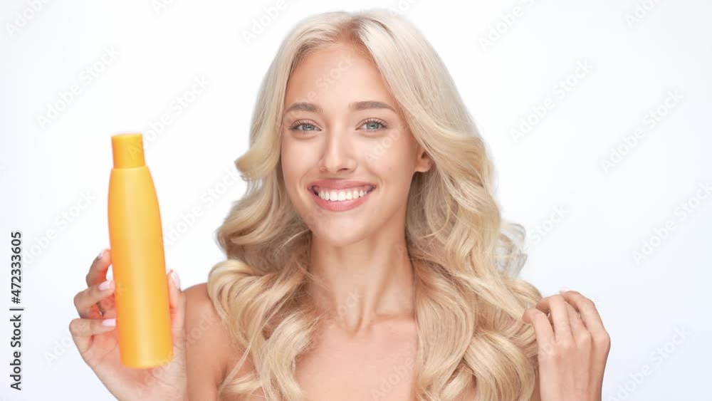 Charming lady touch wavy hair enjoy lotion isolated white color background