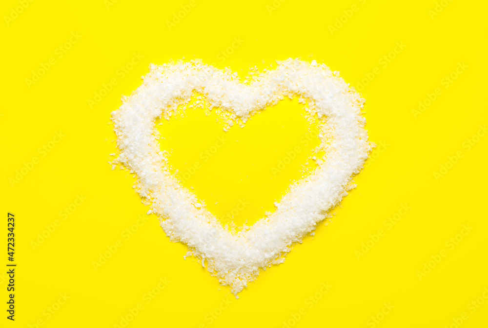 Heart made of snow on yellow background Heart made of snow on yellow background