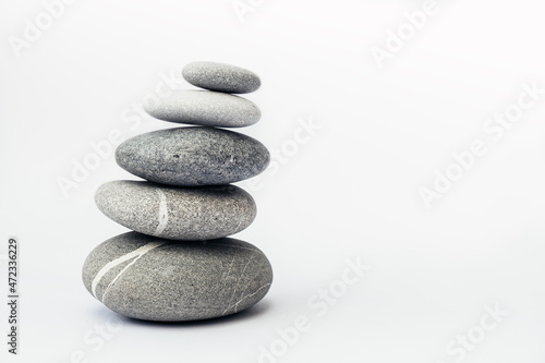 Stone cairn on light background  stones tower  simple poise stones. Purity harmony and Balance Concept. Place for text.
