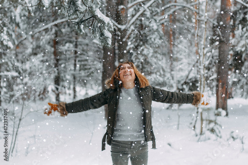 Snow in the air on the background of a blurry image of a happy young girl who throws white snow. Christmas holidays, Winter time © Anastasiya Famina