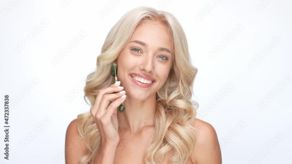 Wavy hair lady apply gua sha massager cheeks isolated white color background Wavy hair lady apply gua sha massager cheeks isolated white color background