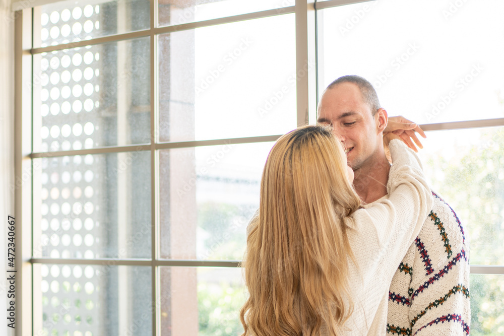 Fototapeta premium Male and female couples or lovers happily snuggle near the windows in the summer.