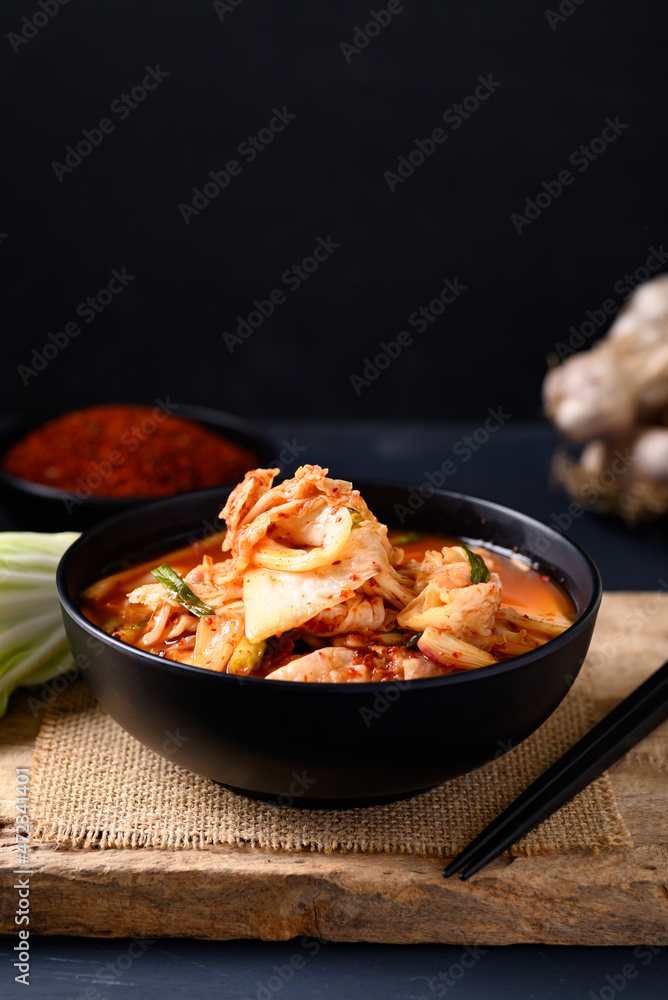 Korean kimchi cabbage in a bowl on wooden with black background, Asian fermented food, Still Life