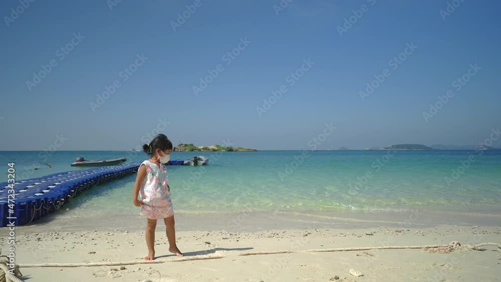 Cute little girl wearing protective face mask standing at sea shore Cute little girl wearing protective face mask standing at sea shore