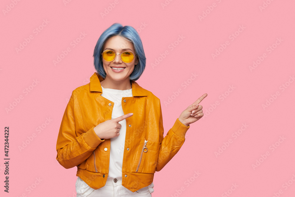 Smiling woman with blue hair pointing away Smiling woman with blue hair pointing away