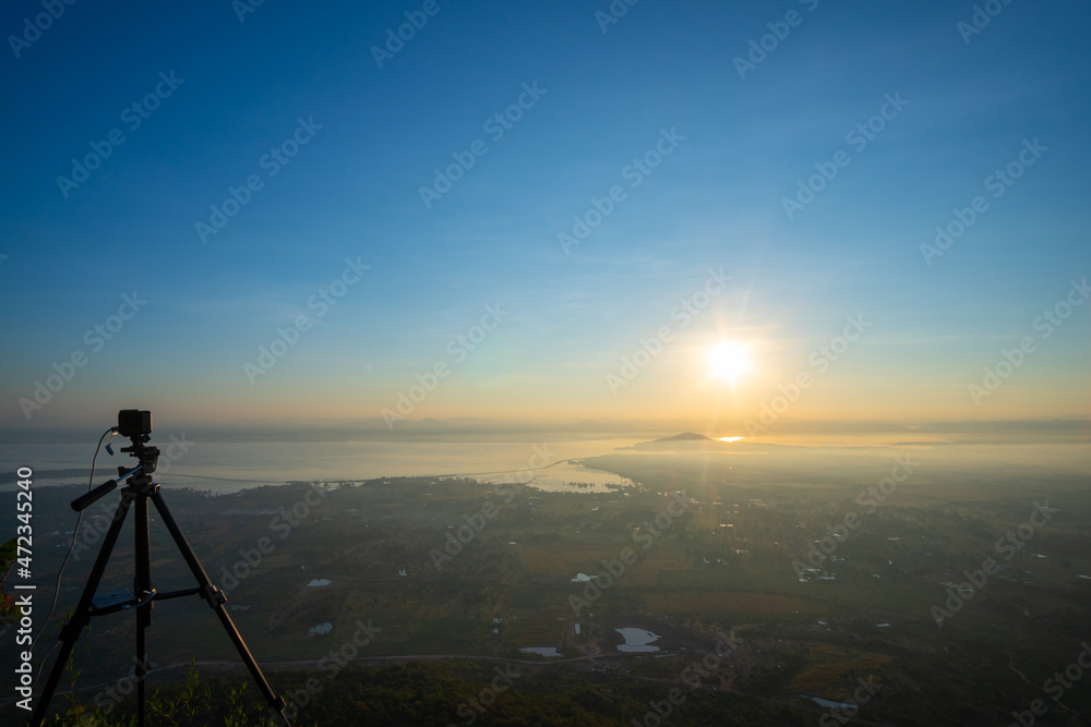 Sunrise over the lake of Pa Sak Jolasid dam with light fog coverage, There is also a camera on the tripod at Lopburi province unseen Thailand, View from 