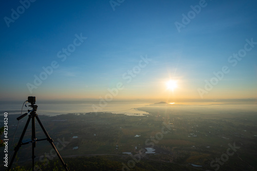 Sunrise over the lake of Pa Sak Jolasid dam with light fog coverage, There is also a camera on the tripod at Lopburi province unseen Thailand, View from "Khao Praya Dern Thong" viewpoint.