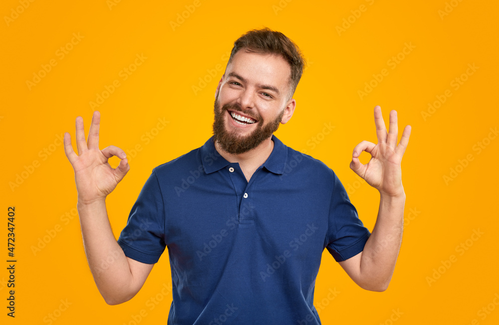 Smiling man showing OK signs on yellow background Smiling man showing OK signs on yellow background