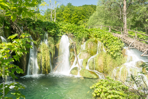 waterfall in the forest backed by wooden walkway