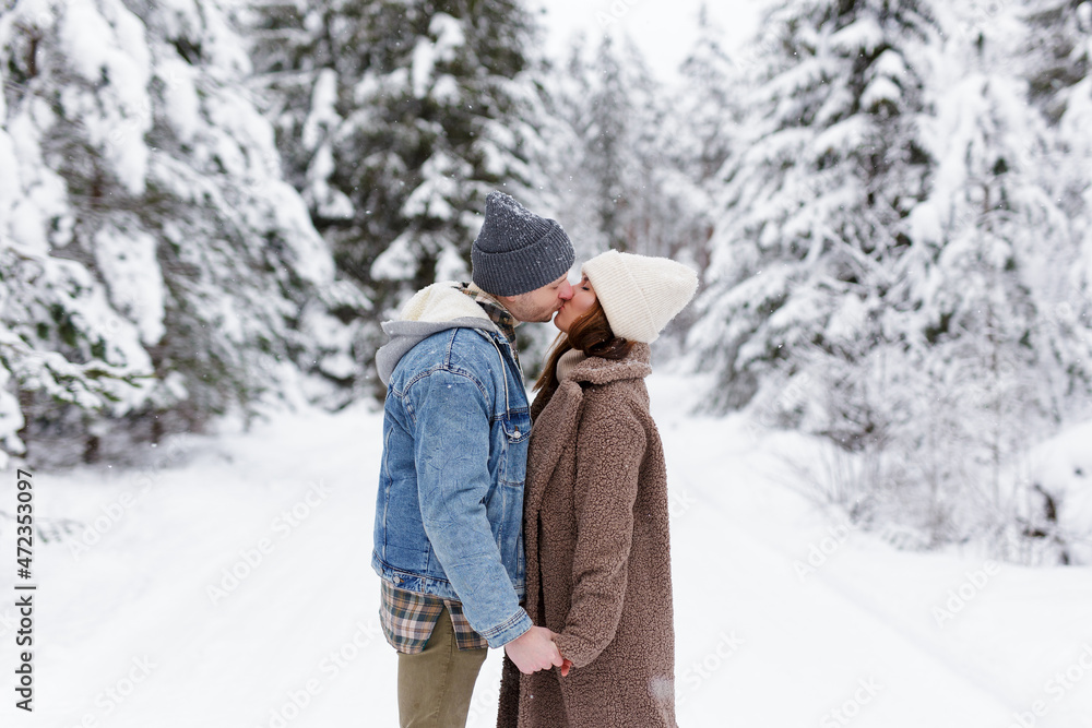 beautiful couple in love kissing in winter forest. beautiful couple in love kissing in winter forest.