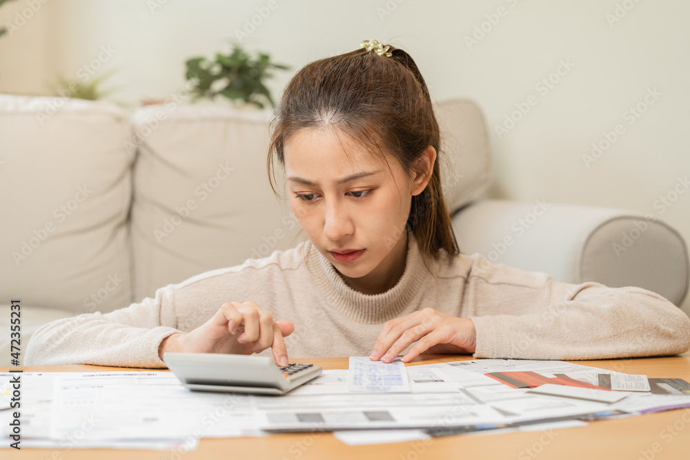 Financial owe asian young woman, girl sitting suffer, stressed and confused by calculate expense from invoice or bill, have no money to pay, mortgage or loan. Debt, bankruptcy or bankruptcy concept. Financial owe asian young woman, girl sitting suffer, stressed and confused by calculate expense from invoice or bill, have no money to pay, mortgage or loan. Debt, bankruptcy or bankruptcy concept.