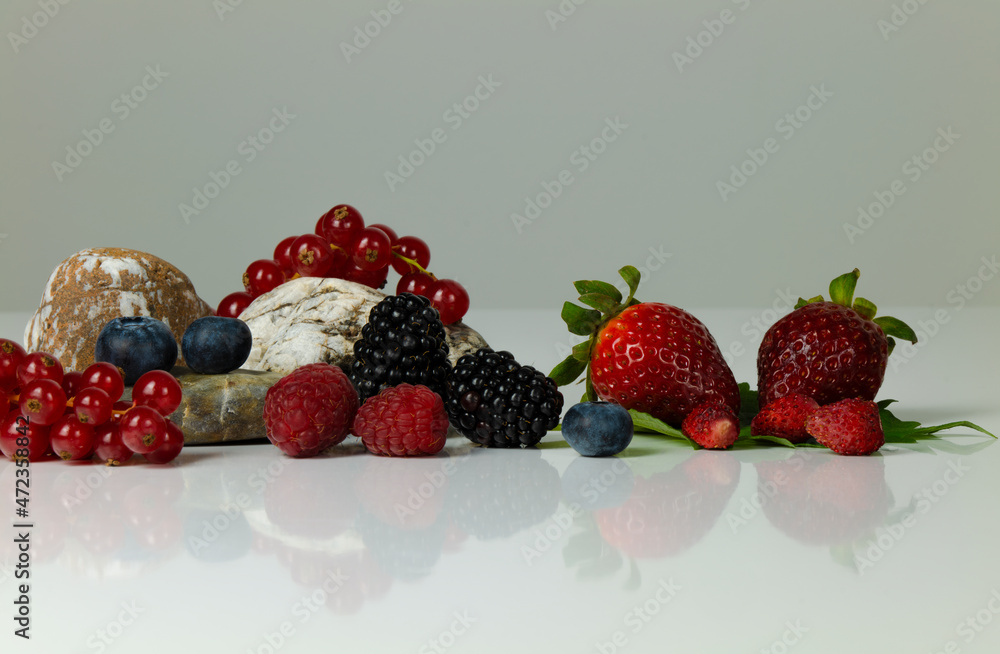Still life of berry fruits on white table against white background Still life of berry fruits on white table against white background