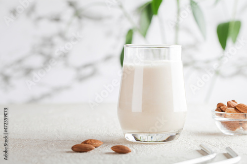 Bild auf Leinwand Vegan almond milk in glass with nuts on white background