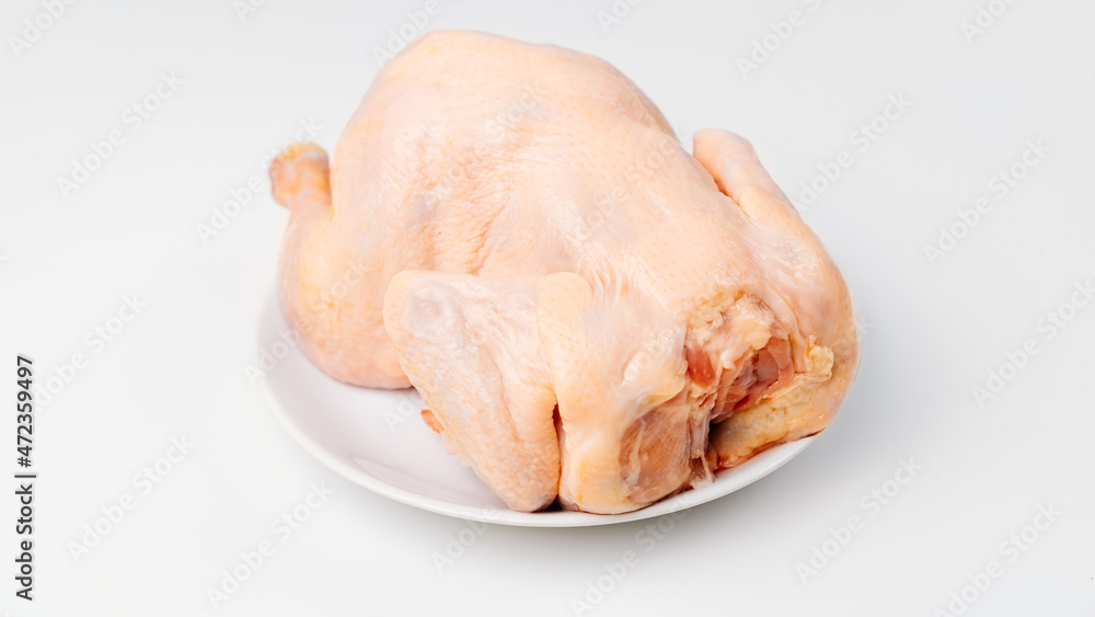 carcass of raw chicken on a white plate on a white background. carcass of raw chicken on a white plate on a white background.