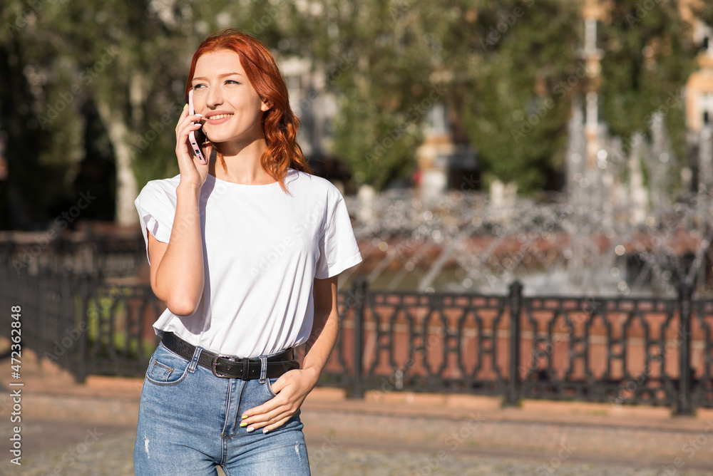 A beautiful, attractive and happy redhead Caucasian girl talking on the phone. Freelance concept. A beautiful, attractive and happy redhead Caucasian girl talking on the phone. Freelance concept.