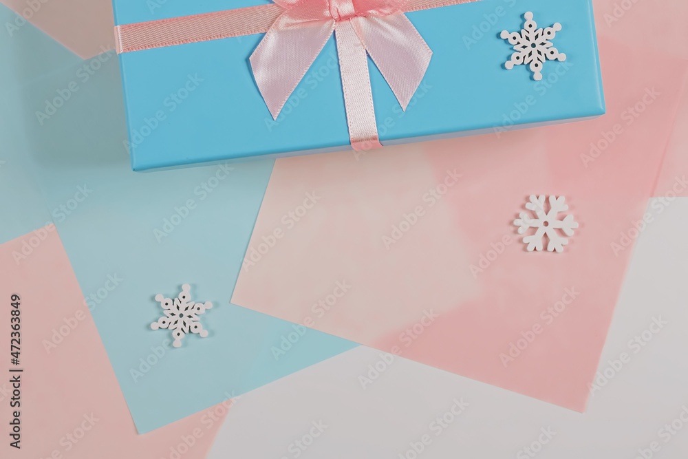Christmas minimalistic concept. Gift box tied with a ribbon with snowflakes. Flat style, top view, place for text