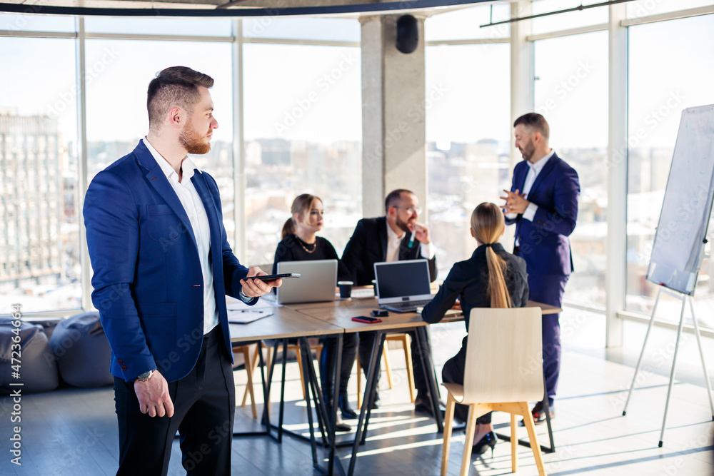 Business people, businessmen are working together in a modern office in a multi-storey skyscraper. The director is on the phone. Office work concept. Selective focus Business people, businessmen are working together in a modern office in a multi-storey skyscraper. The director is on the phone. Office work concept. Selective focus