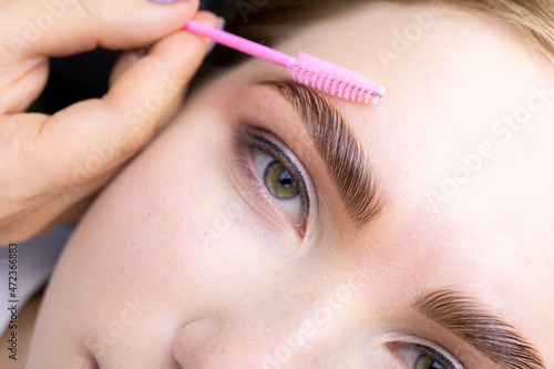 Obraz na plátně macro photography of the model's hairs the master combs the eyebrow hairs with a