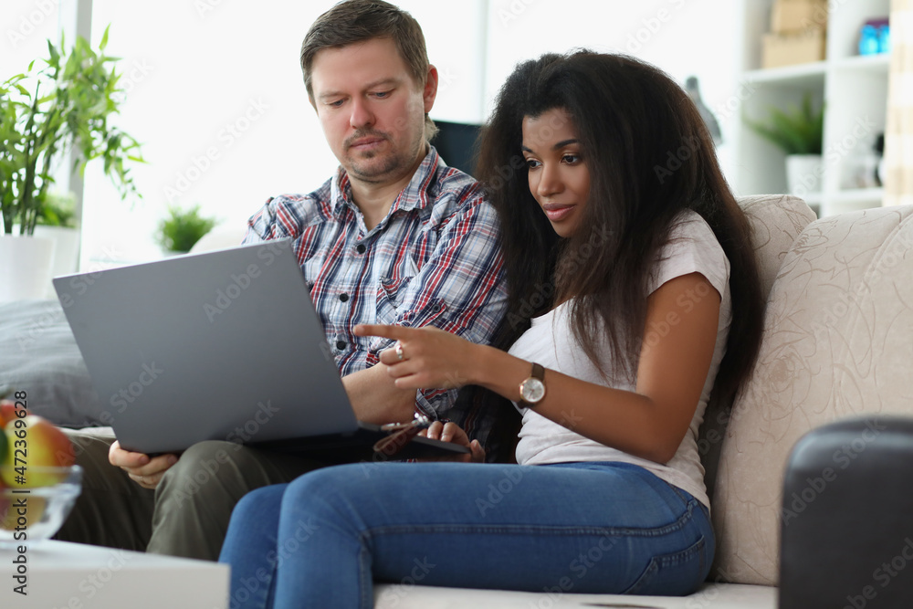 Middle aged man and latino american woman choosing something online Middle aged man and latino american woman choosing something online