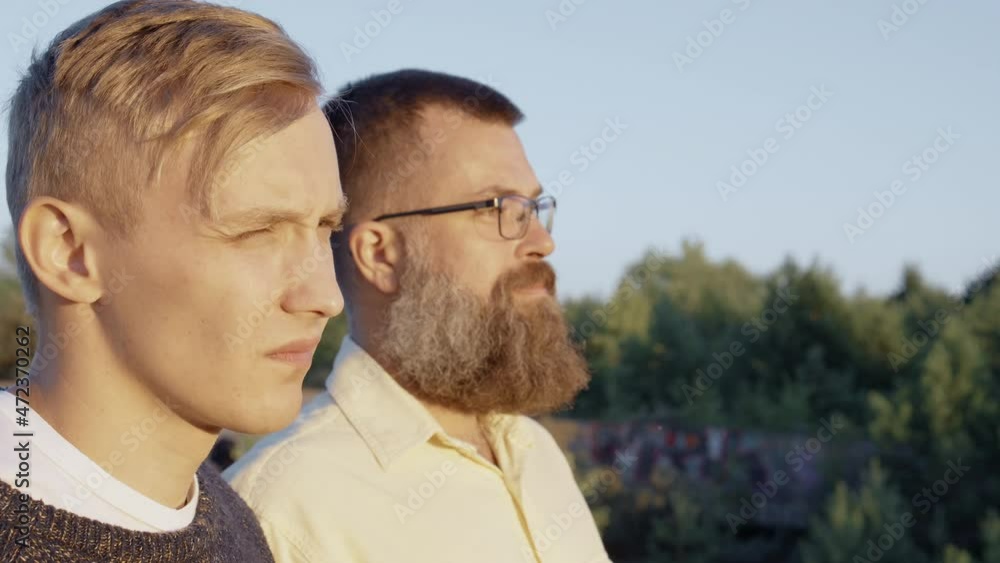 Video of two men standing outdoor during sunrise in summer Video of two men standing outdoor during sunrise in summer