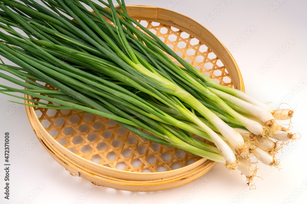 Fresh spring onion in bamboo basket isolated on white background, Green onion on White Background With clipping path. Fresh spring onion in bamboo basket isolated on white background, Green onion on White Background With clipping path.
