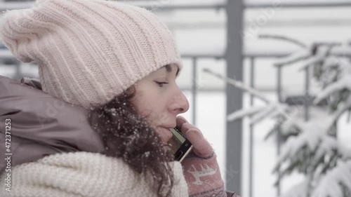 Outdoor winter portrait. Beautiful woman 45 years old talking on a cell phone in a snowy winter park